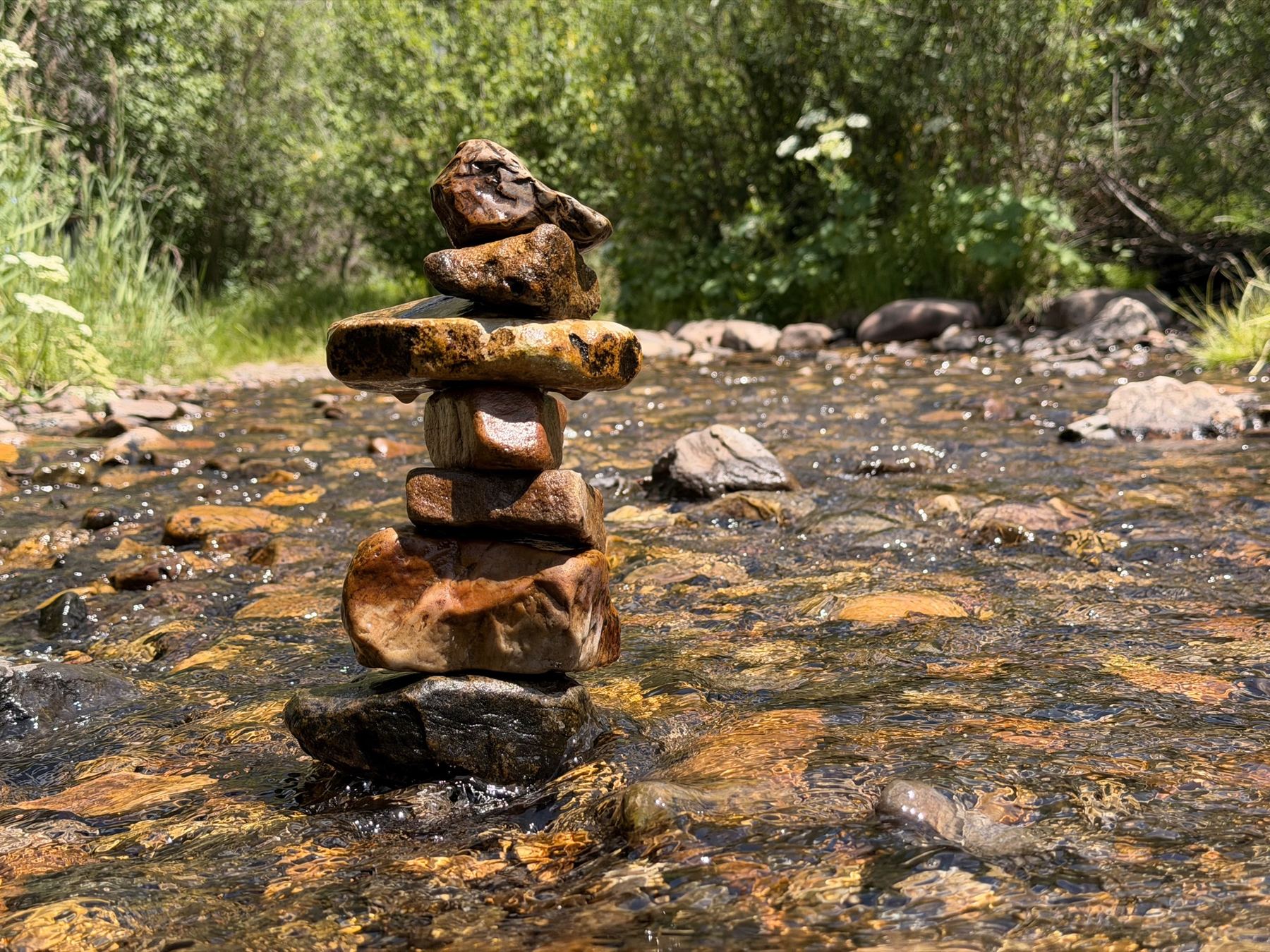 A hand-stacked stone cairn balanced in a mountain creek